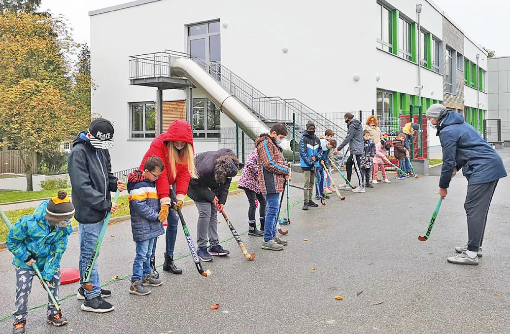Kinder beim Hockey-Spielen-Lernen