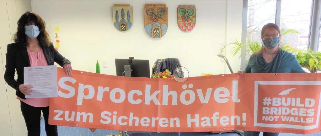 In ihrem Amtszimmer nimmt Bürgermeisterin Sabine Noll (links) von Flüchtlingshilfe-Koordinatorin Miriam Venn die Petition „Sprockhövel zum Sicheren Hafen“ mit 900 Unterschriften entgegen.