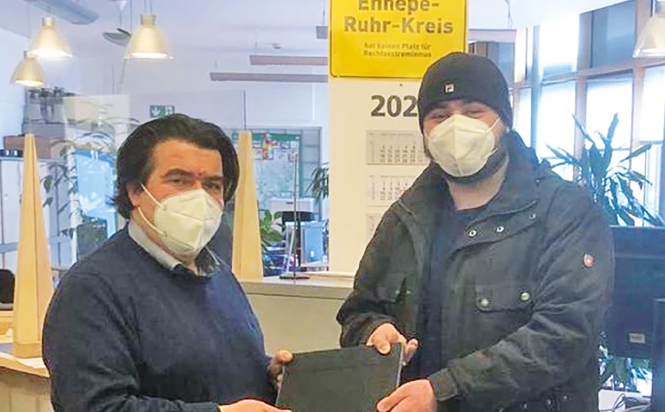 Olaf Schmiemann, Schulleiter am Berufskolleg Witten, händigt seinem Schüler Alhomam Fannad ein Leihgerät aus