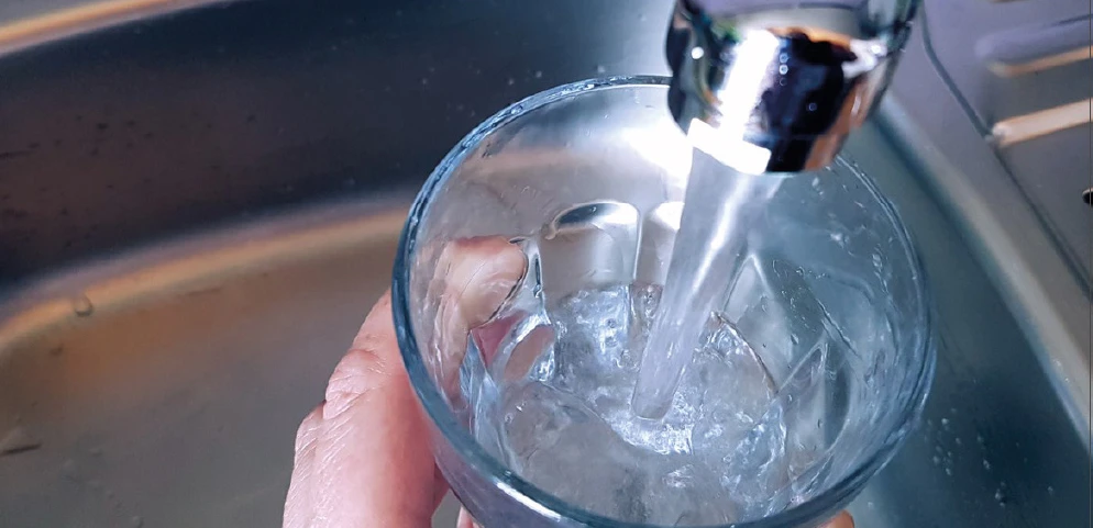 Kranwasser fließt in Glas