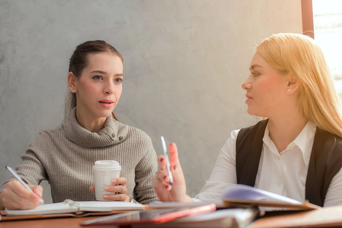 Zwei Frauen im Gespräch am Tisch