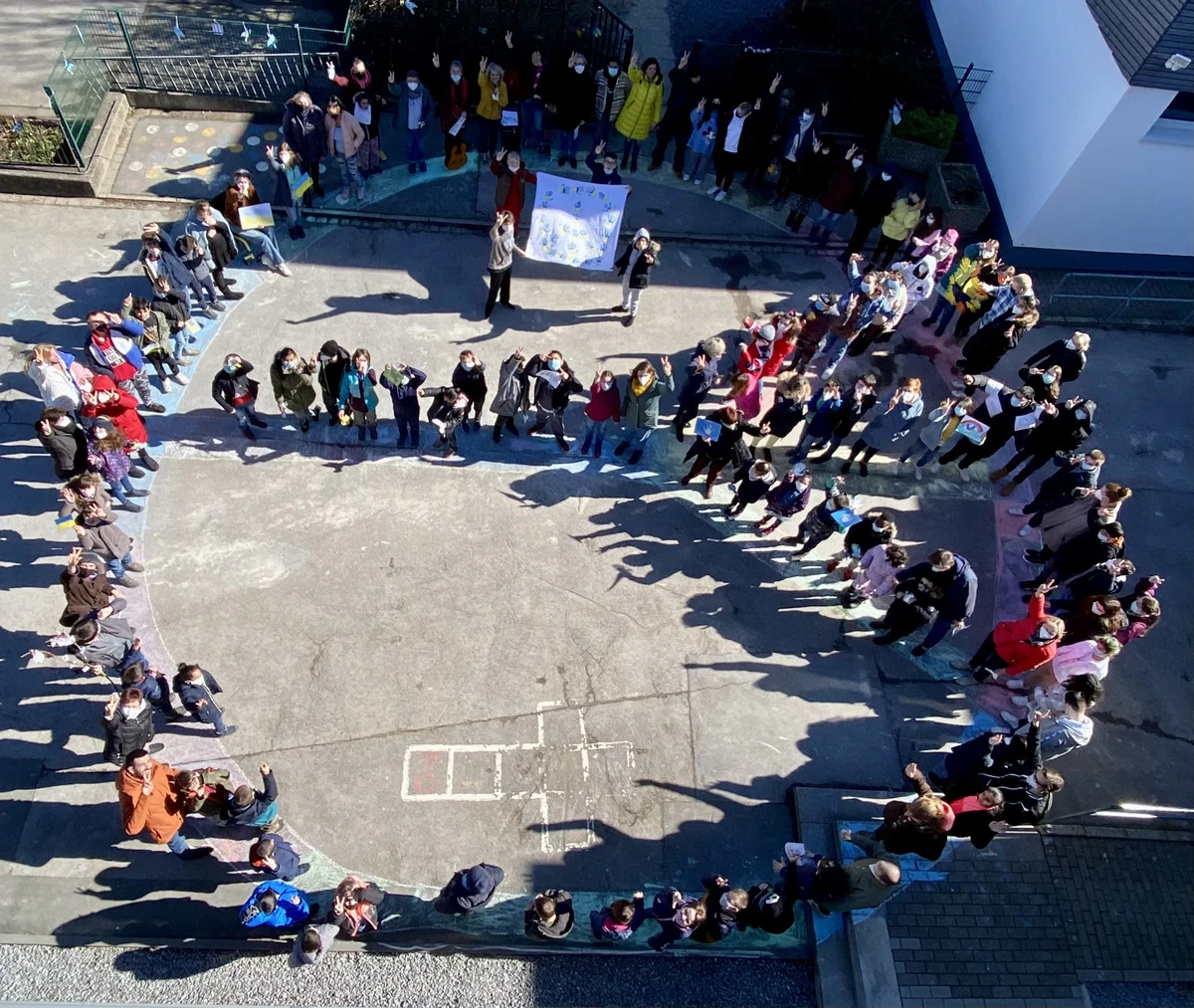  Das auf dem Schulhof gebildete riesengroßen Peace-Zeichen
