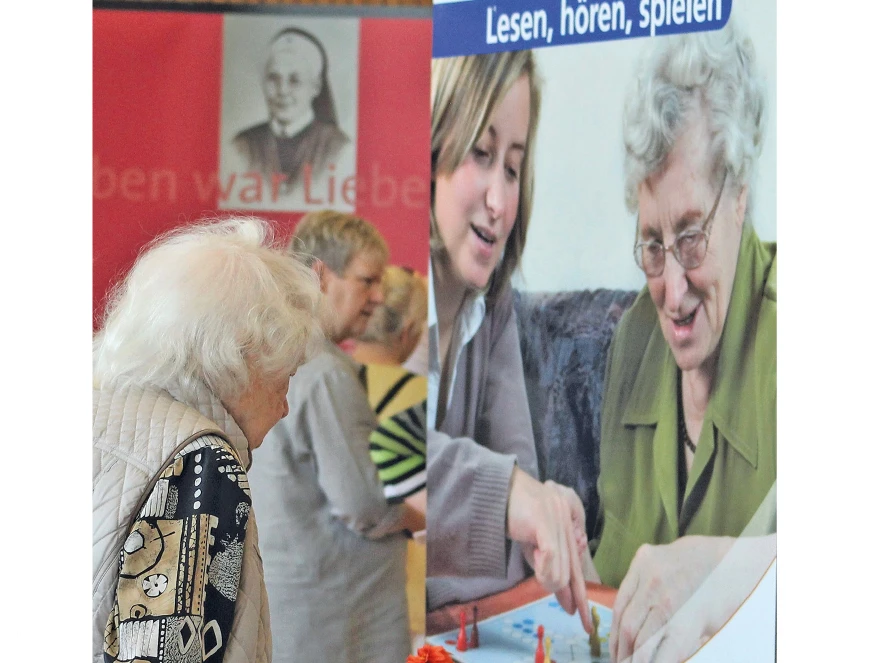 Alte Frau vor Plakat "Demenz"